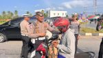 Personel Satlantas Polres Bintan membagikan takjil kepada pengendara di Bundaran Km 16 Toapaya